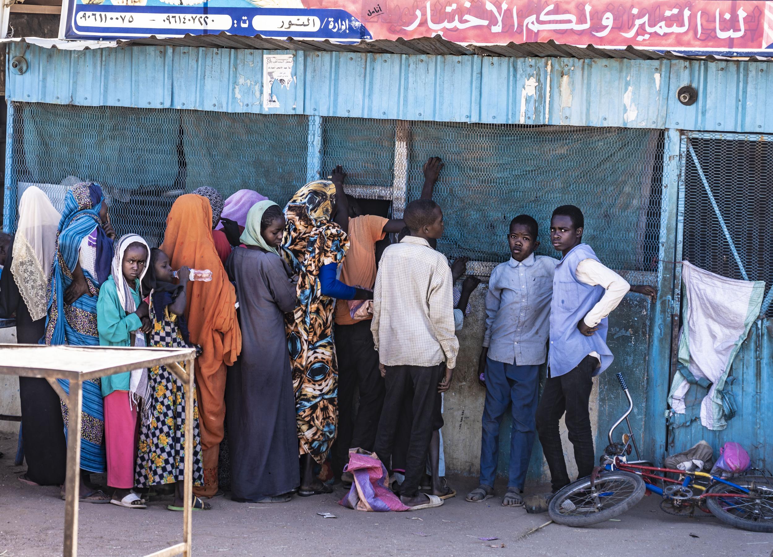 Displaced families queue for bread amid shortages at Zamzam camp in North Darfur