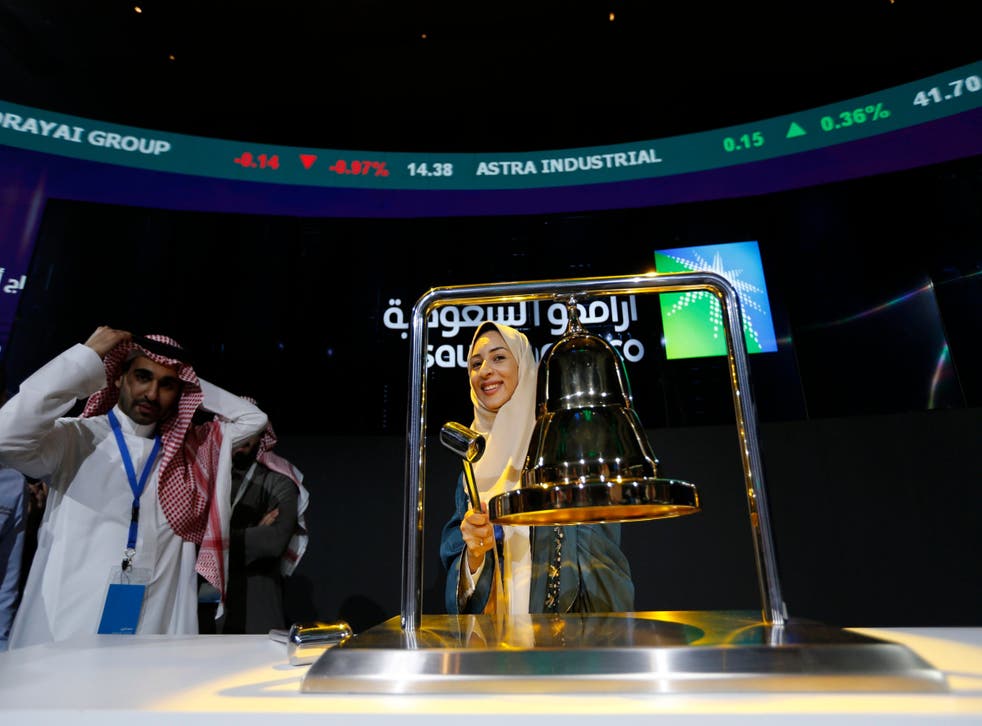 An Aramco employee rings the Tadawul exchange's opening bell to begin trading of the Saudi oil firm's shares