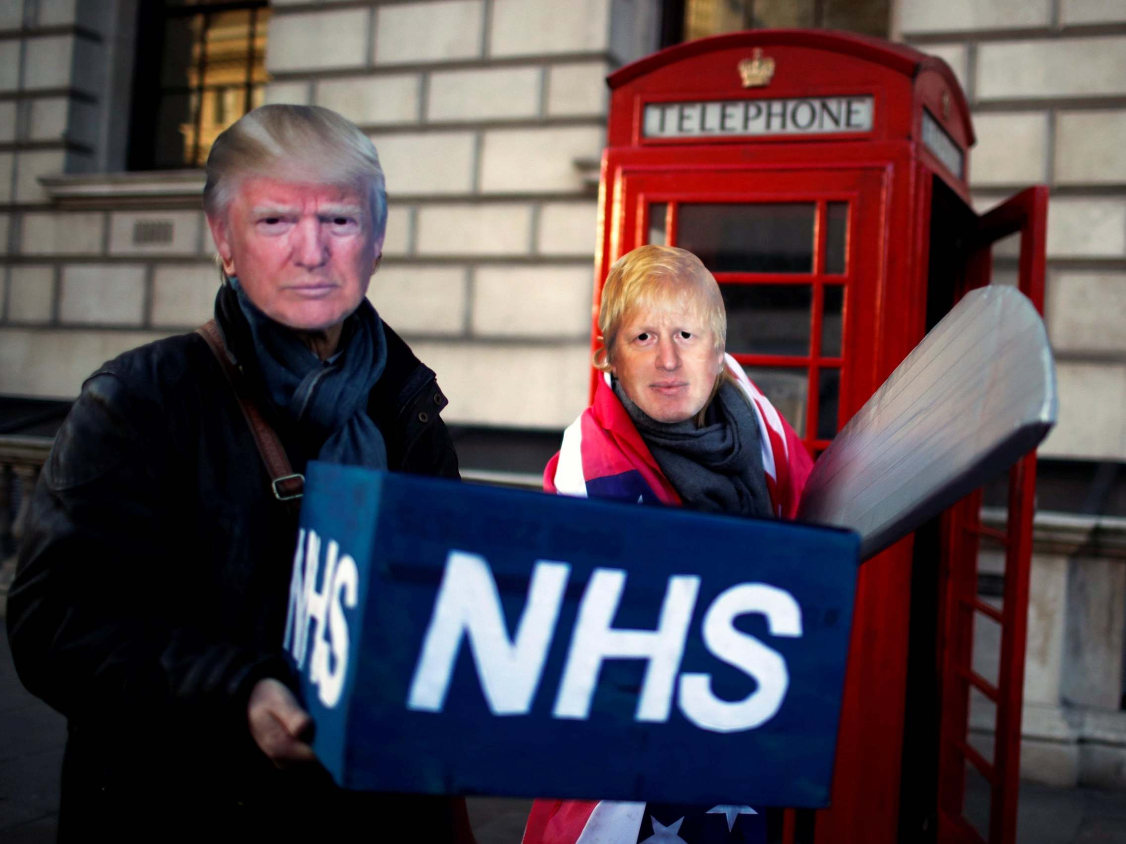 Healthcare professionals dressed as Boris Johnson and Donald Trump attend a demonstration demanding the NHS be protected from commercial exploitation
