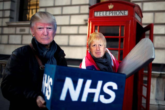 Healthcare professionals dressed as Boris Johnson and Donald Trump attend a demonstration demanding the NHS be protected from commercial exploitation