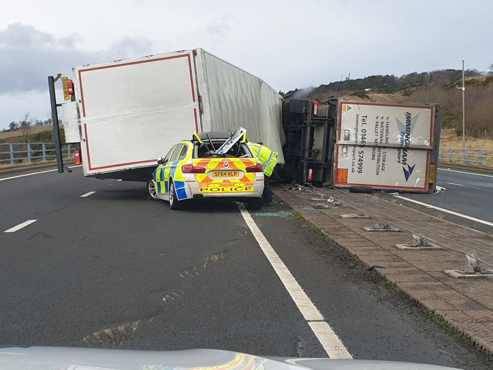 A police car was crushed by a lorry after it was blown over by strong winds on the A1 in Scotland while he was attending to another toppled HGV on 10 December, 2019.