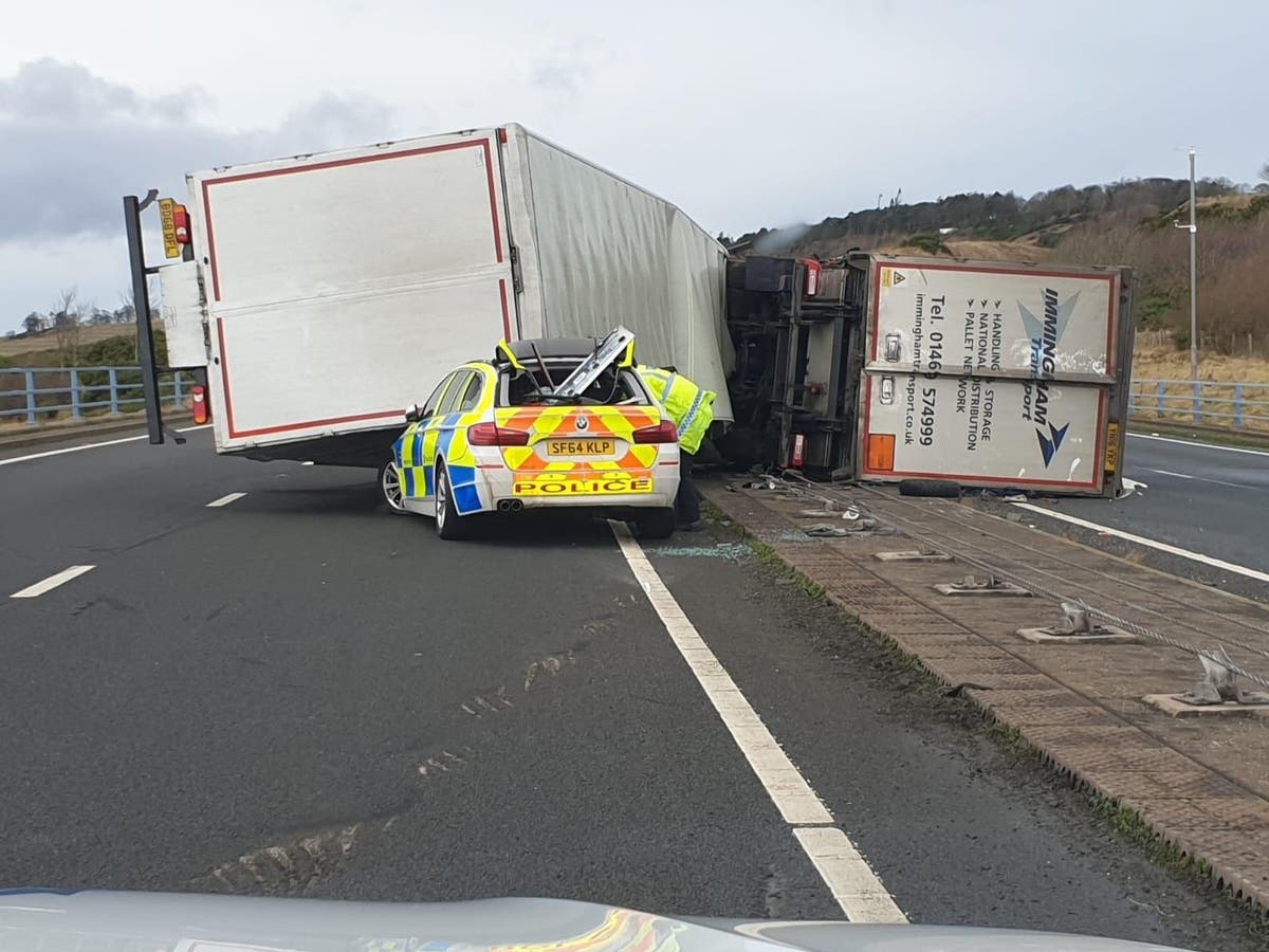 Lorry crushes police car on busy road in strong winds