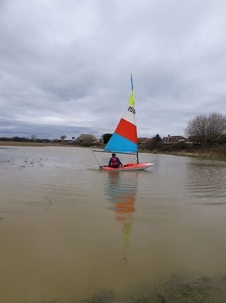 A boat being sailed on a site at Pagham, West Sussex, earmarked for houses (Gill Homer/CPRE Sussex)