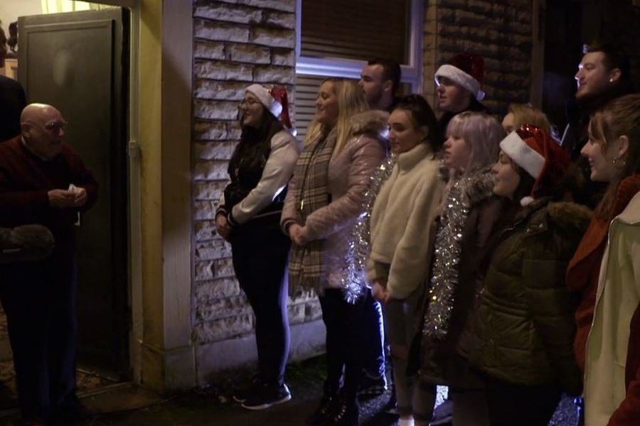 Terrence listens to carolers from Oldham College singing ‘Silent Night’