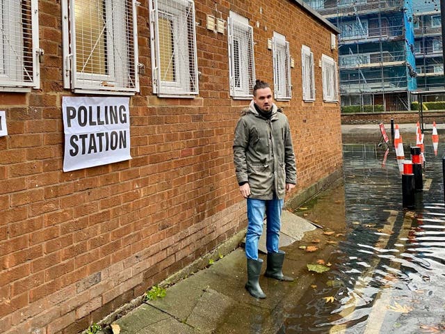 Adam McNeil stands outside Cherry Garden Hall polling station in Bermondsey, London, which was surrounded by water after a burst water main