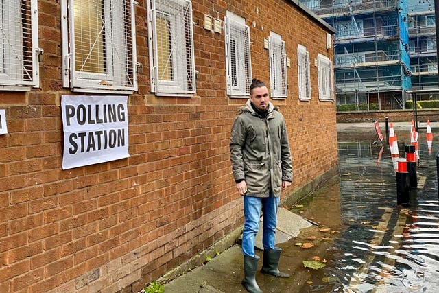 Adam McNeil stands outside Cherry Garden Hall polling station in Bermondsey, London, which was surrounded by water after a burst water main