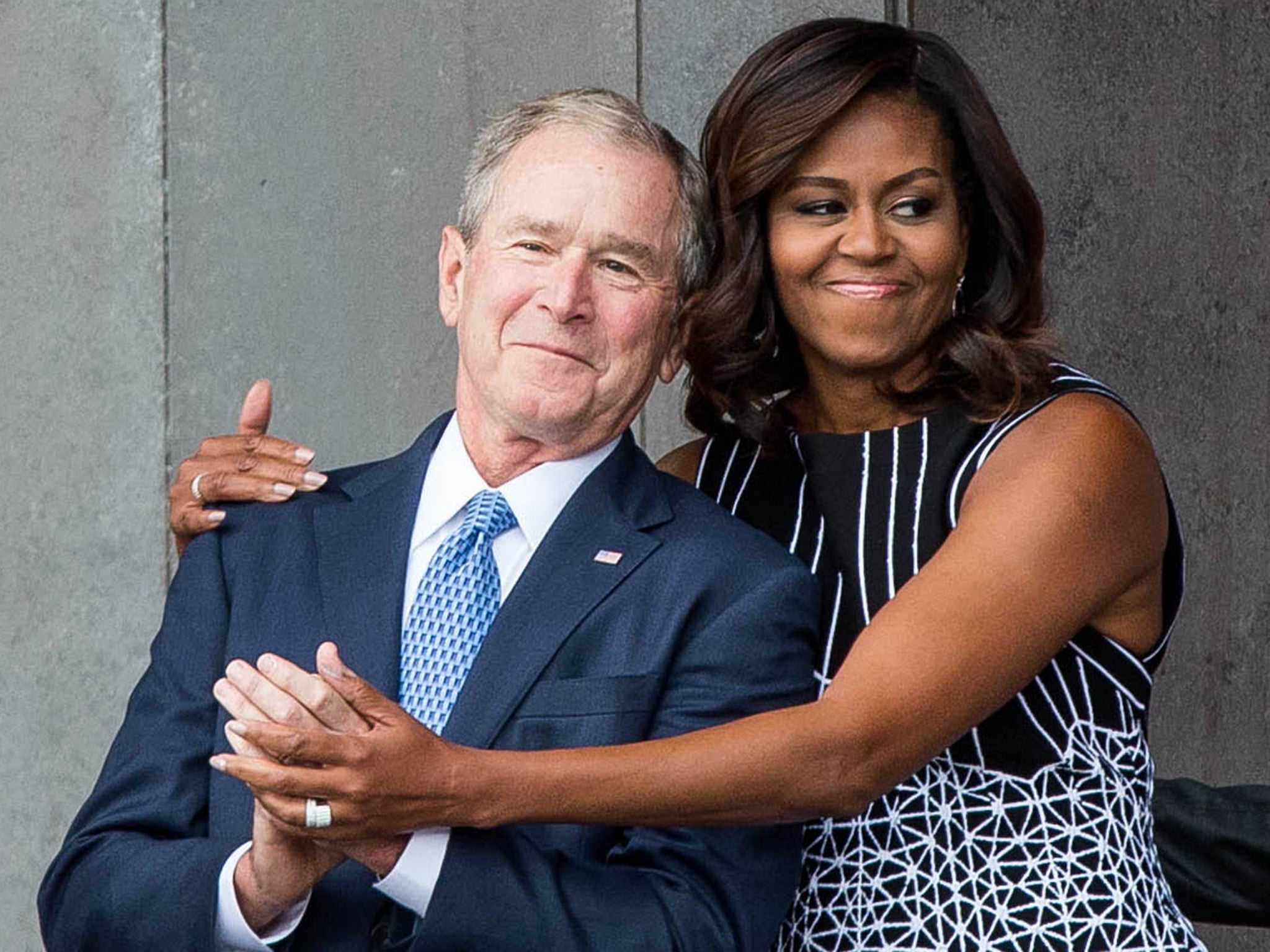 Michelle Obama and George W Bush hug at a opening ceremony for the Smithsonian National Museum of African American History and Culture in Washington in 2016
