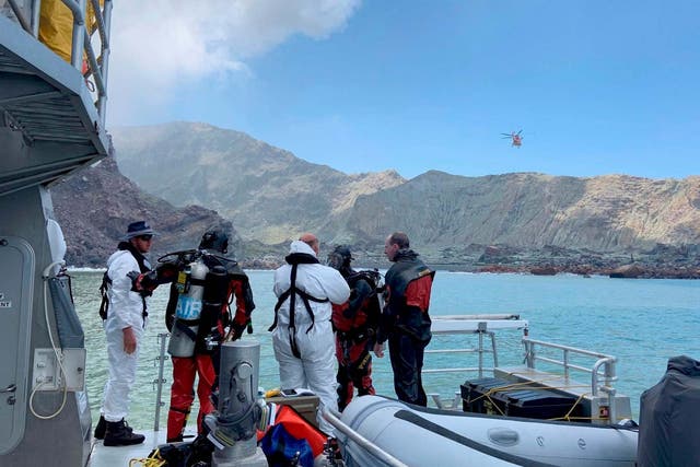 Police divers prepare to search for a body seen in waters after the eruption