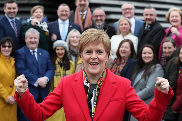 Scotland's first minister Nicola Sturgeon celebrates as she joins the SNP's newly elected MPs for a group photo call outside the V&A Museum in Dundee