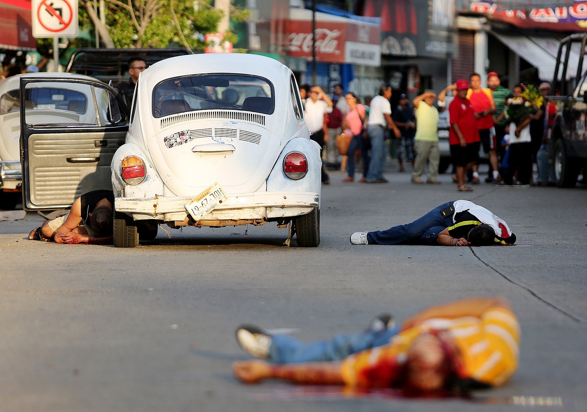 The bodies of three dead people lie on a street in downtown Acapulco, Guerrero State, – one of Mexico's poorest states where a lucrative drug trade has flourished.