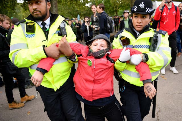 Police arrest a climate activist near Downing Street during the third day of climate change demonstrations by Extinction Rebellion in London on October 9, 2019.