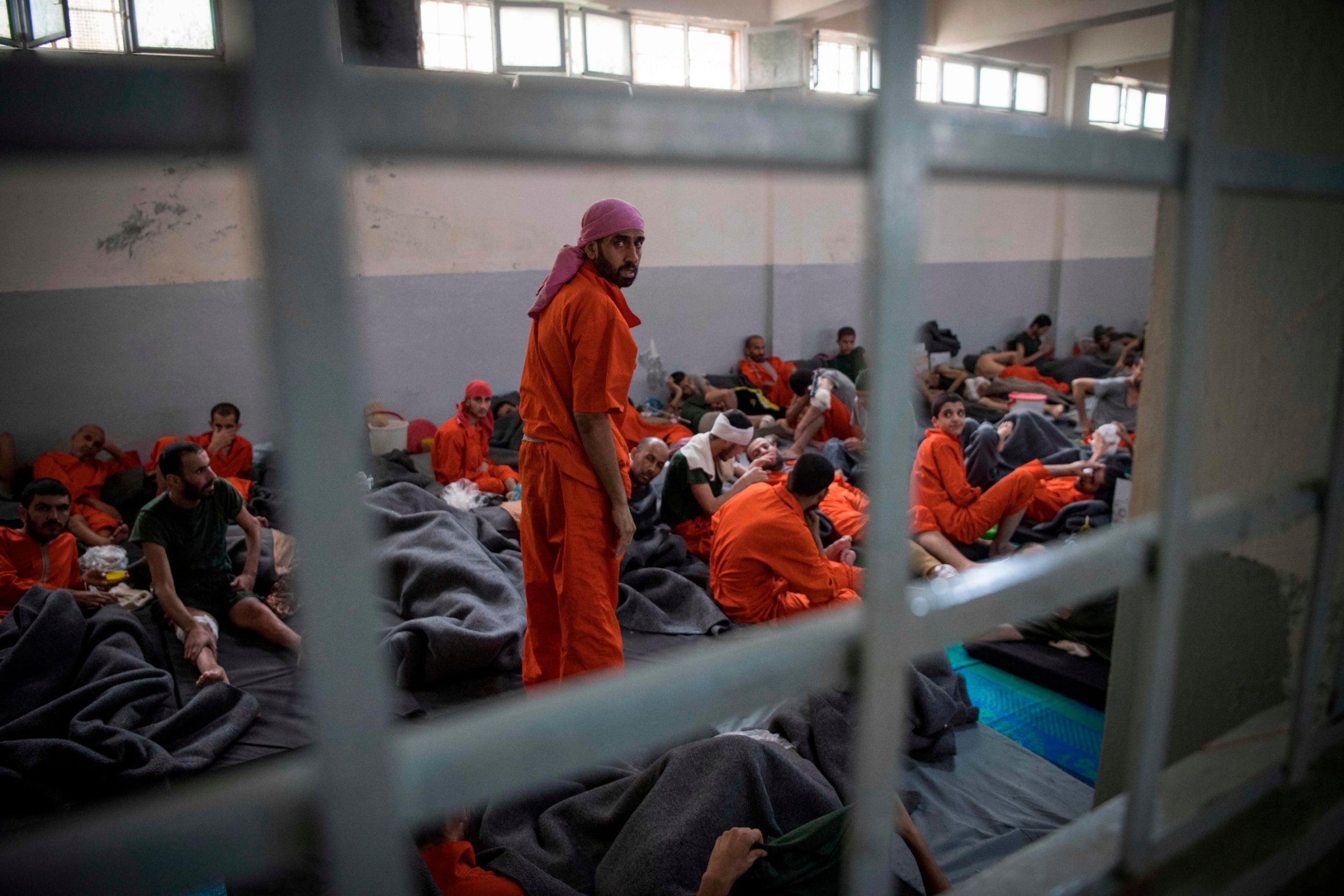 Men allegedly affiliated with Isis sit on the floor in a prison in the northeastern Syrian city of Hassakeh