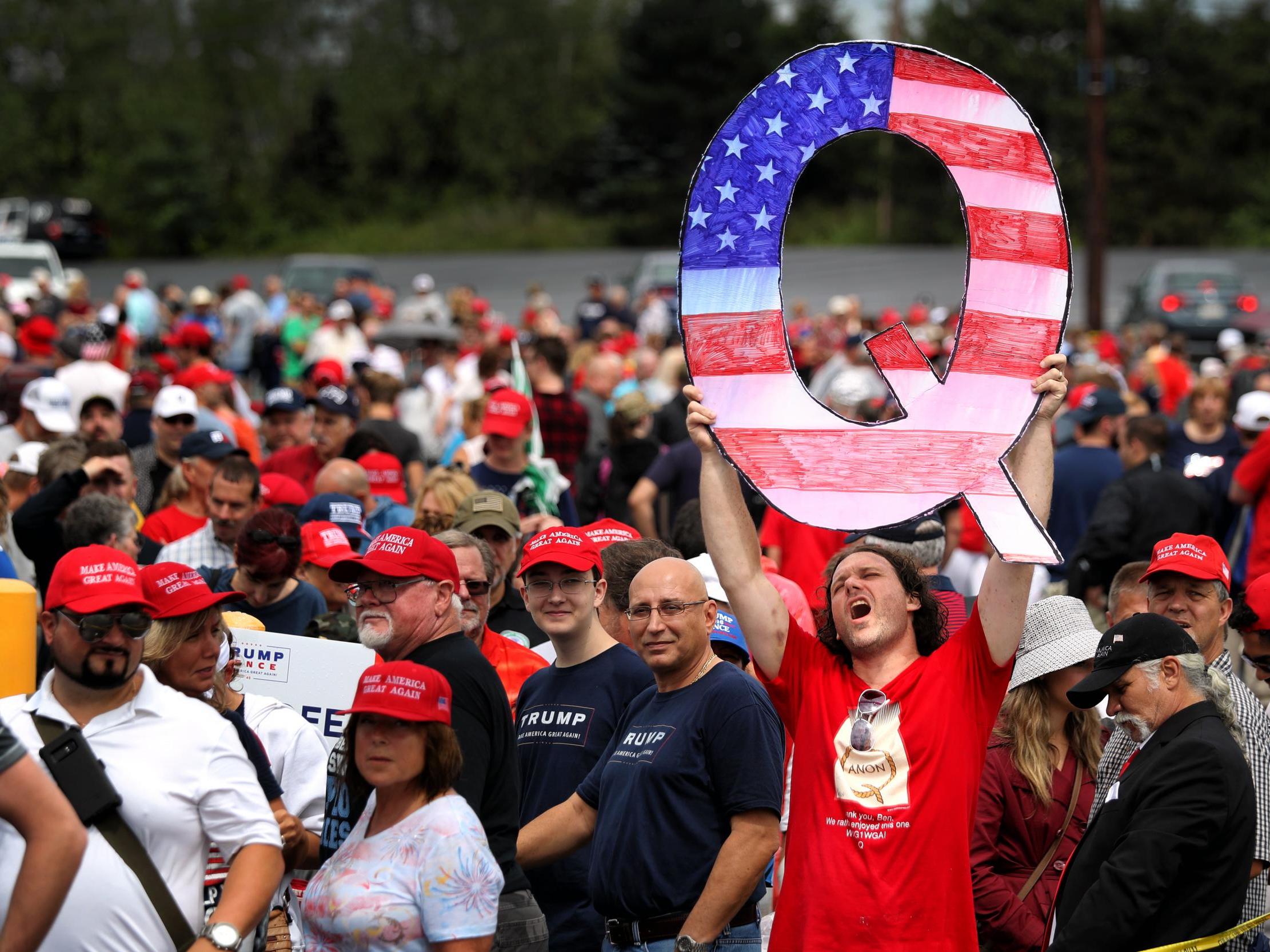David Reinert, of the conspiracy theory group QAnon, waits to see Trump at a rally