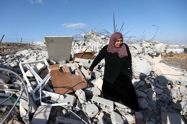 A Palestinian woman checks ruins of a house after it was demolished by Israeli troops in the West Bank village of Khader, near Bethlehem