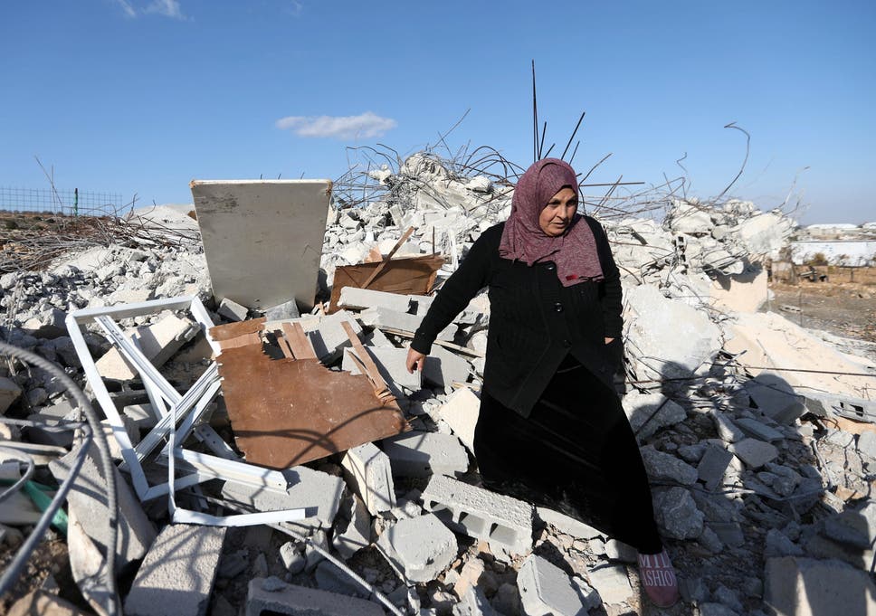 A Palestinian woman checks ruins of a house after it was demolished by Israeli troops in the West Bank village of Khader, near Bethlehem