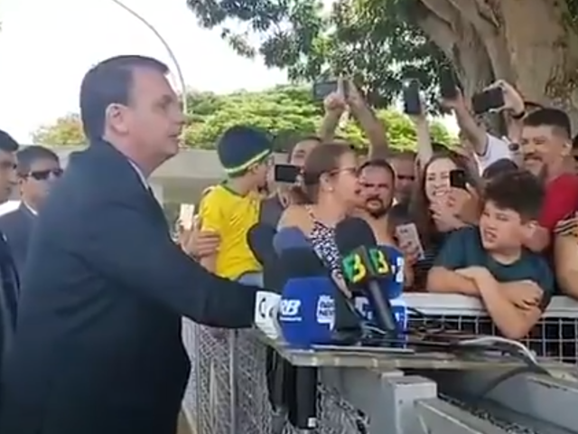 Jair Bolsonaro cheered by fans as he launches a homophobic attack on a reporter outside his palace