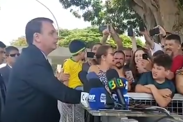 Jair Bolsonaro cheered by fans as he launches a homophobic attack on a reporter outside his palace