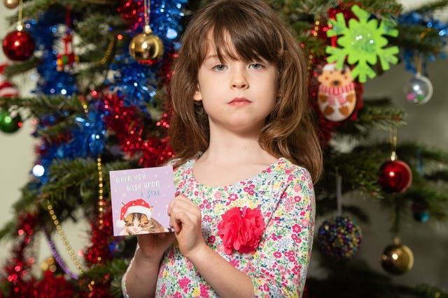 Florence Widdicombe, six, holds a card from the pack in which she discovered a message from an alleged prisoner