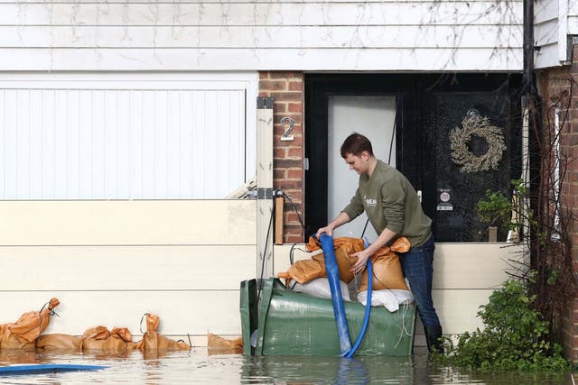 A man attempts to pump water out of his home in Yalding, Kent, after the area flooded following heavy rain