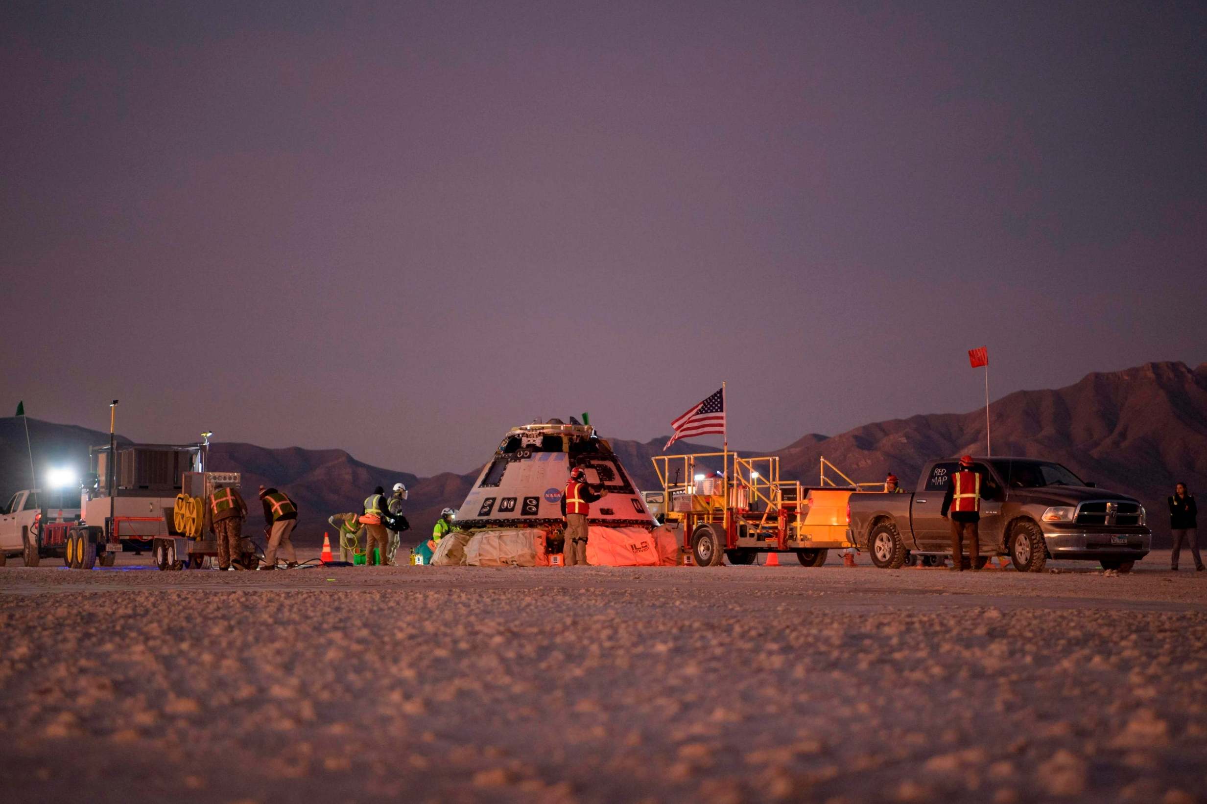 Boeing, NASA, and US Army personnel work around the Boeing CST-100 Starliner spacecraft shortly after it landed in White Sands, New Mexico, on 22 December, 2019.