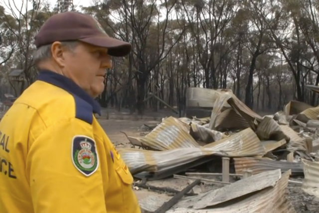Russell Scholes speaks outside the ruins of his house which burned in a wildfire in Australia