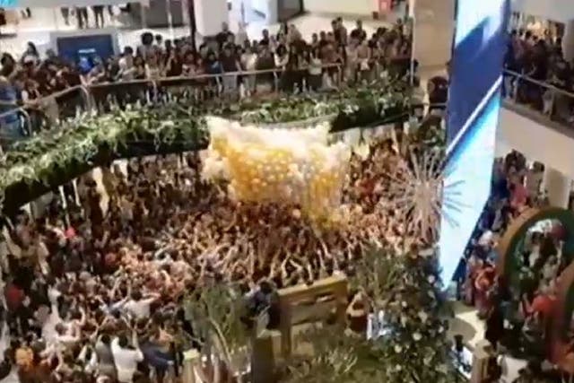 Still image from video by Jonathan Nott of shoppers jostling for balloons containing gift vouchers at Westfield Parramatta in Sydney, Australia, 23 December, 2019.