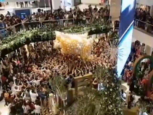 Still image from video by Jonathan Nott of shoppers jostling for balloons containing gift vouchers at Westfield Parramatta in Sydney, Australia, 23 December, 2019.