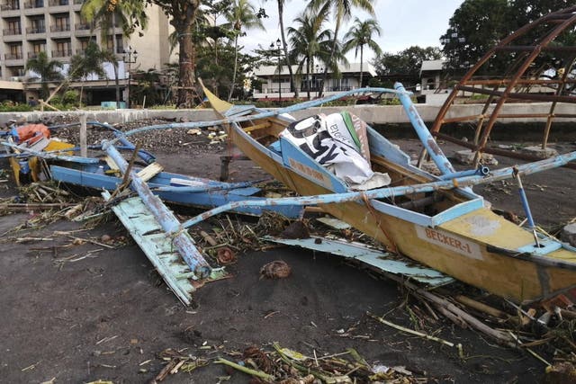 An outrigger boat destroyed by Typhoon Phanfone sits on the coastline