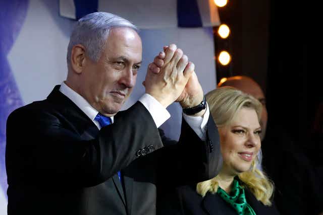 Israeli Prime Minister Benjamin Netanyahu, accompanied by his wife Sara, addresses Likud party supporters during an electoral meeting in the Israeli city of Petah Tikva near Tel Aviv