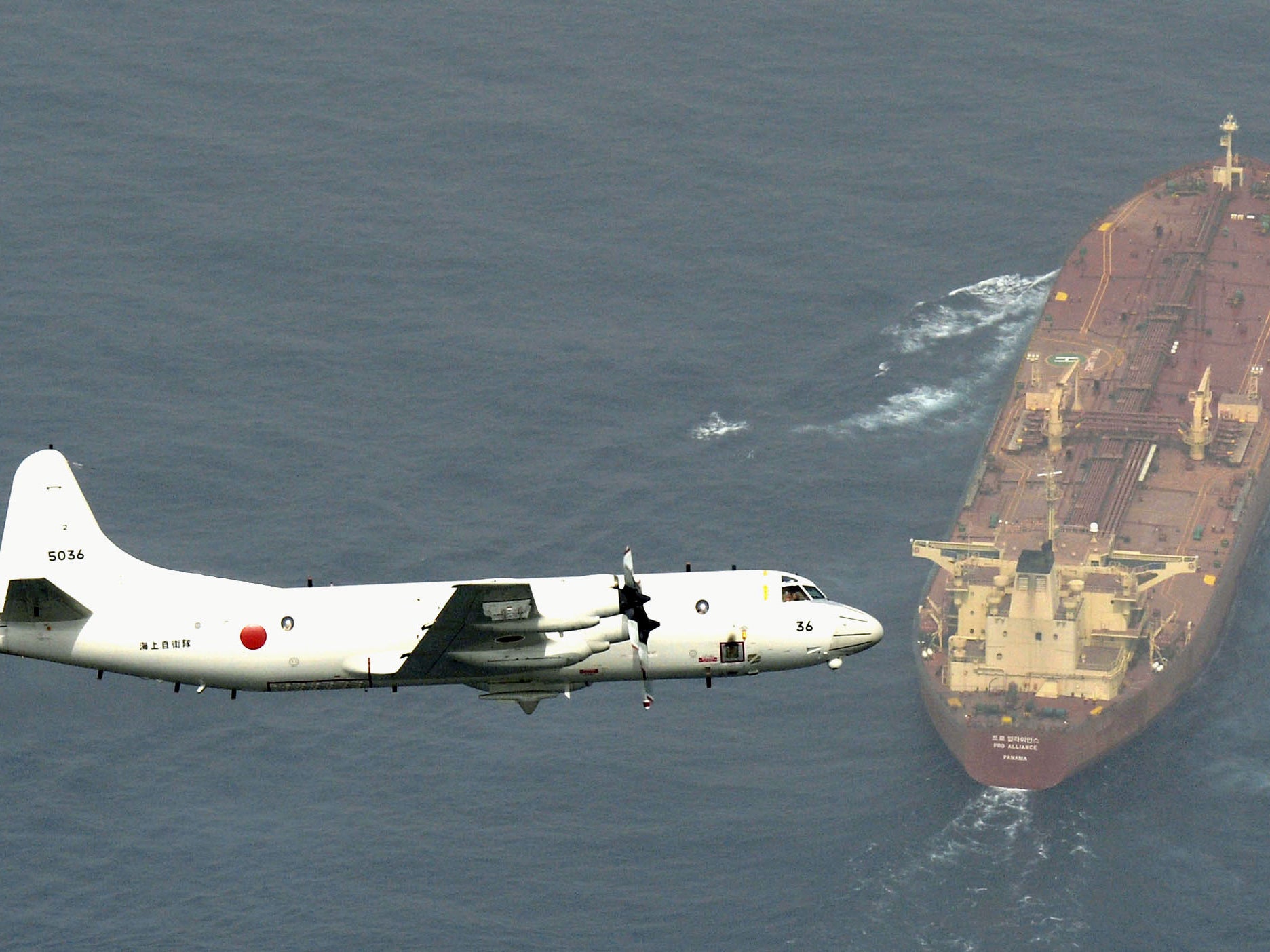 A Self-Defense Force's P3-C Orion surveillance aircraft flies over an oil tanker