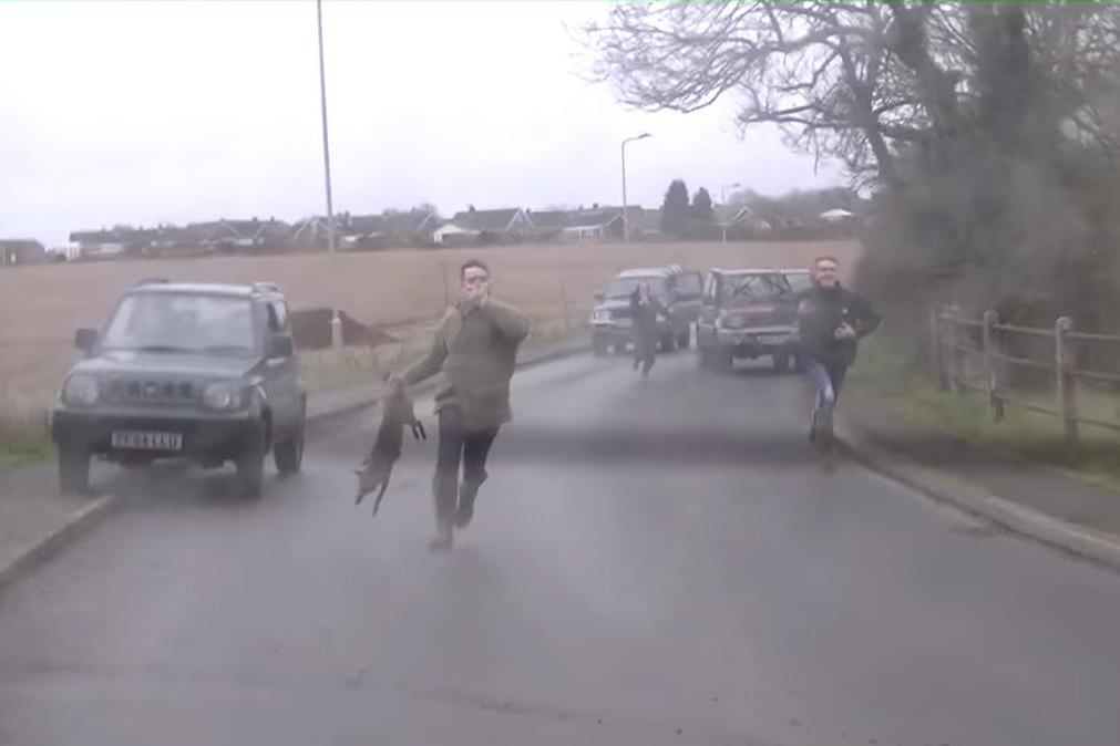 The man was filmed running after the animal rights activists with a dead fox in his hand