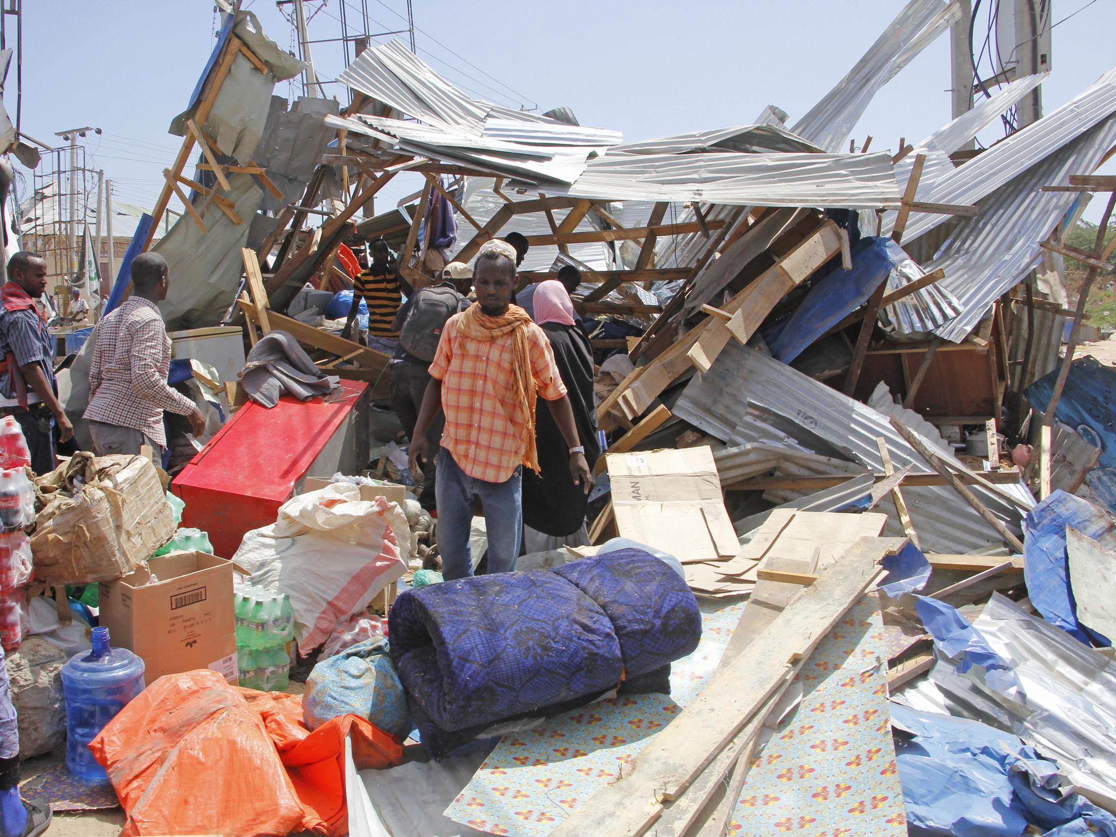Locals salvage goods after shops were destroyed in a car bomb in Mogadishu on 28 December