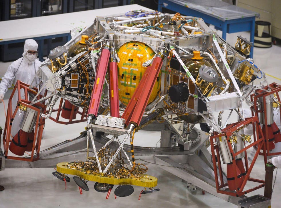 NASA engineers and technicians reposition the Mars 2020 spacecraft descent stage December 27, 2019 during a media tour of the spacecraft assembly area clean room at NASA's Jet Propulsion Laboratory in Pasadena, California