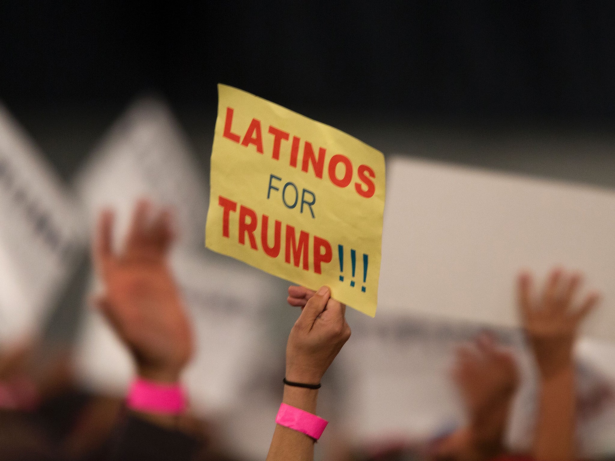 A woman hoods a sign expressing Latino support for Mr Trump
