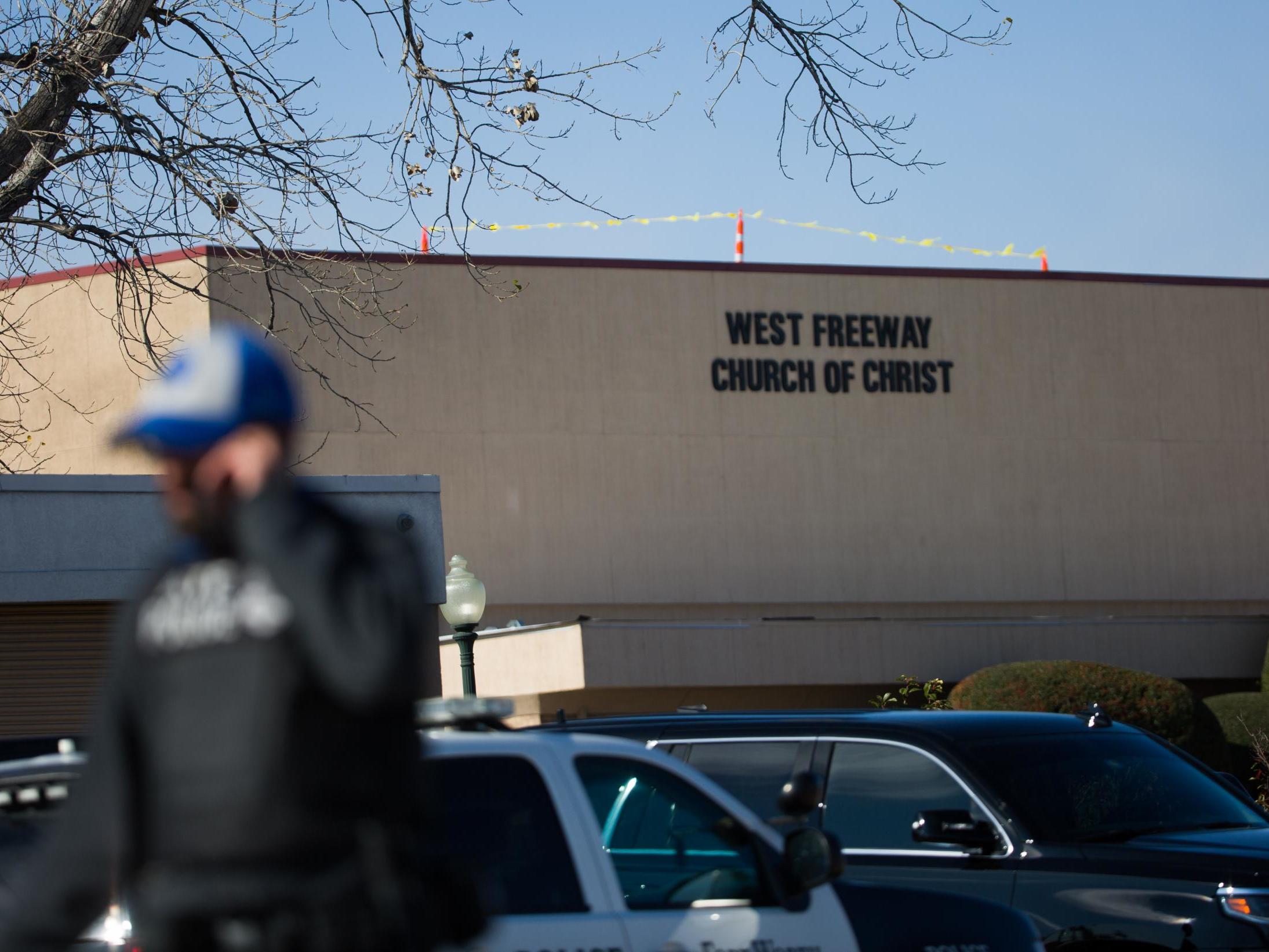 An officer walks near the scene after a church shooting at West Freeway Church of Christ on Sunday