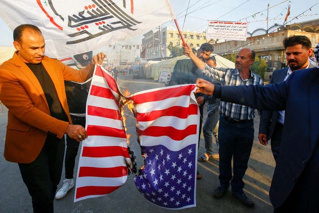 Demonstrators burn a US flag in protest after an airstrike on the Hezbollah militia group in Iraq