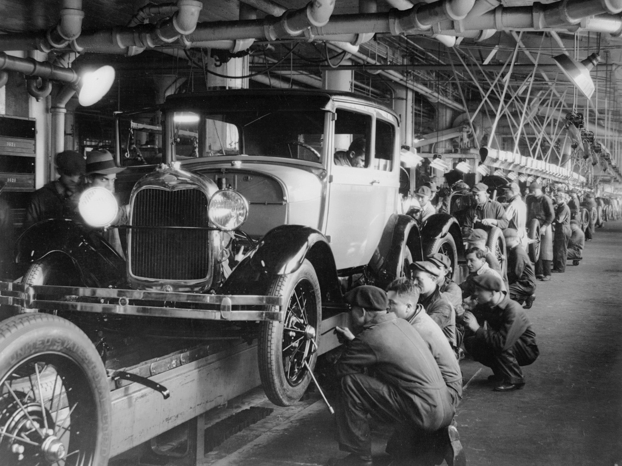 1927: Labourers assemble Ford cars at a factory in Michigan