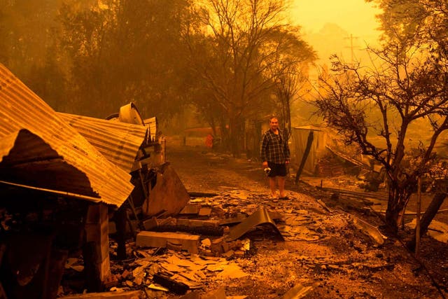 A resident stands among rubble after fires devastated the New South Wales town of Cobargo