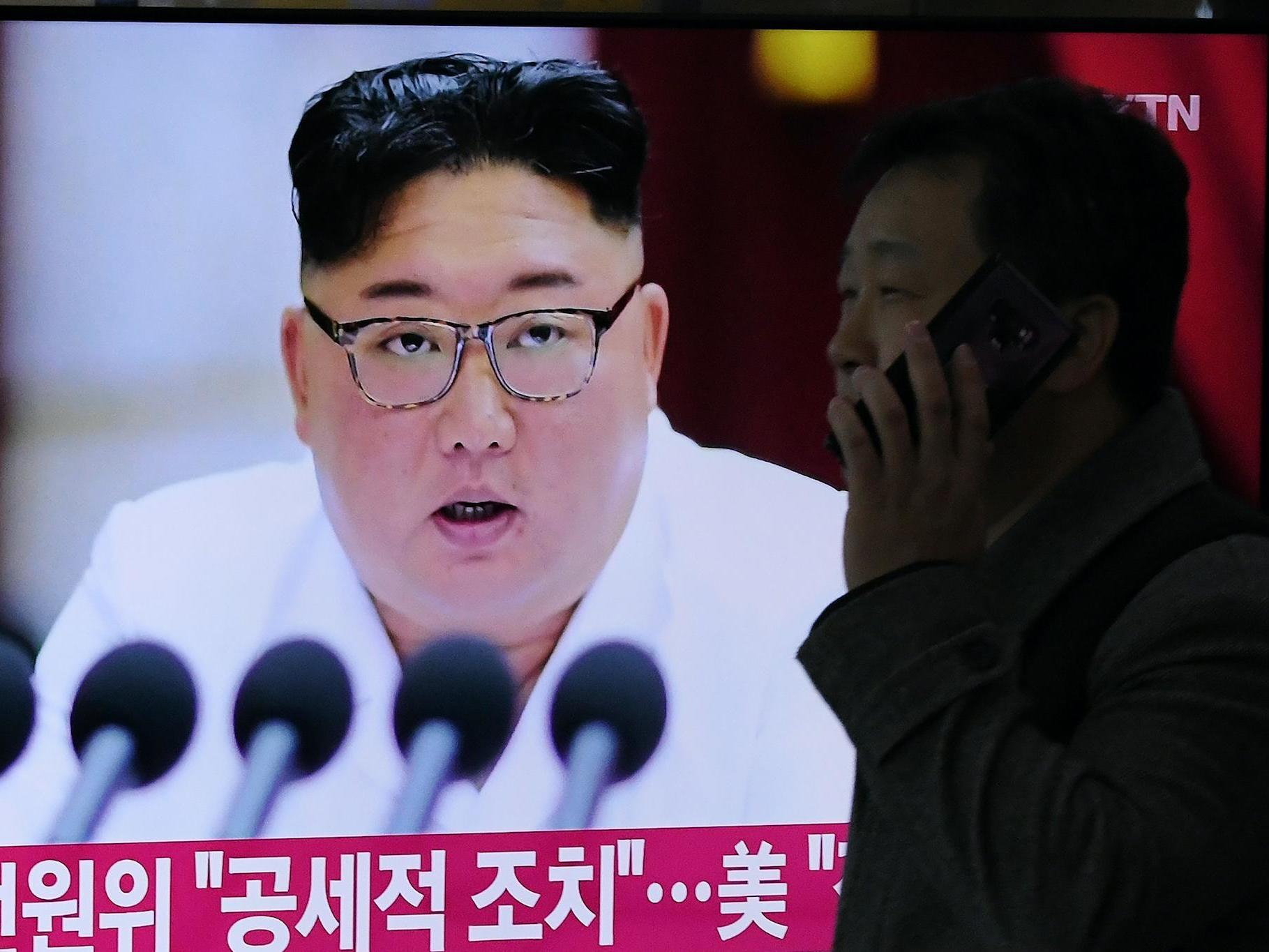 A man walks past a television news program showing the latest pictures of North Korean leader Kim Jong Un, at a railway station in Seoul on December 30, 2019