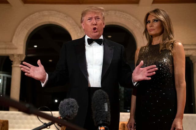 Donald Trump speaks to reporters first lady Melania Trump before his New Year's Eve party