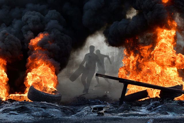 A demonstrator throws a tyre on a fire in Beirut last year