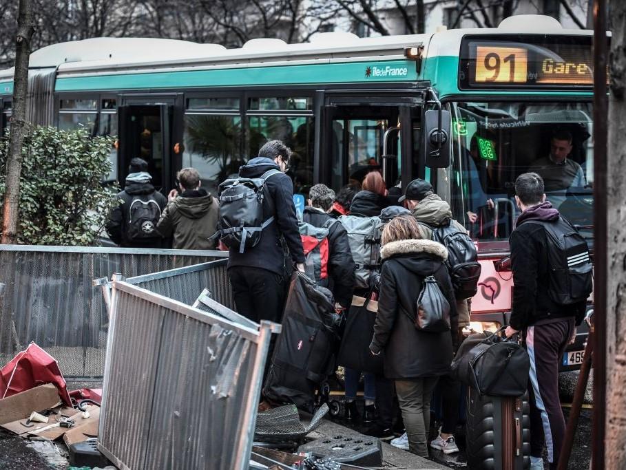 Commuters try to get on a bus in Paris on 2 January, 2020, on the 29th day of a nationwide multi-sector strike against the government's pensions overhaul