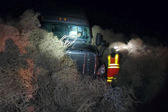A vehicle is trapped by a pile of tumbleweeds along State Route 240 near Richland, Wash.