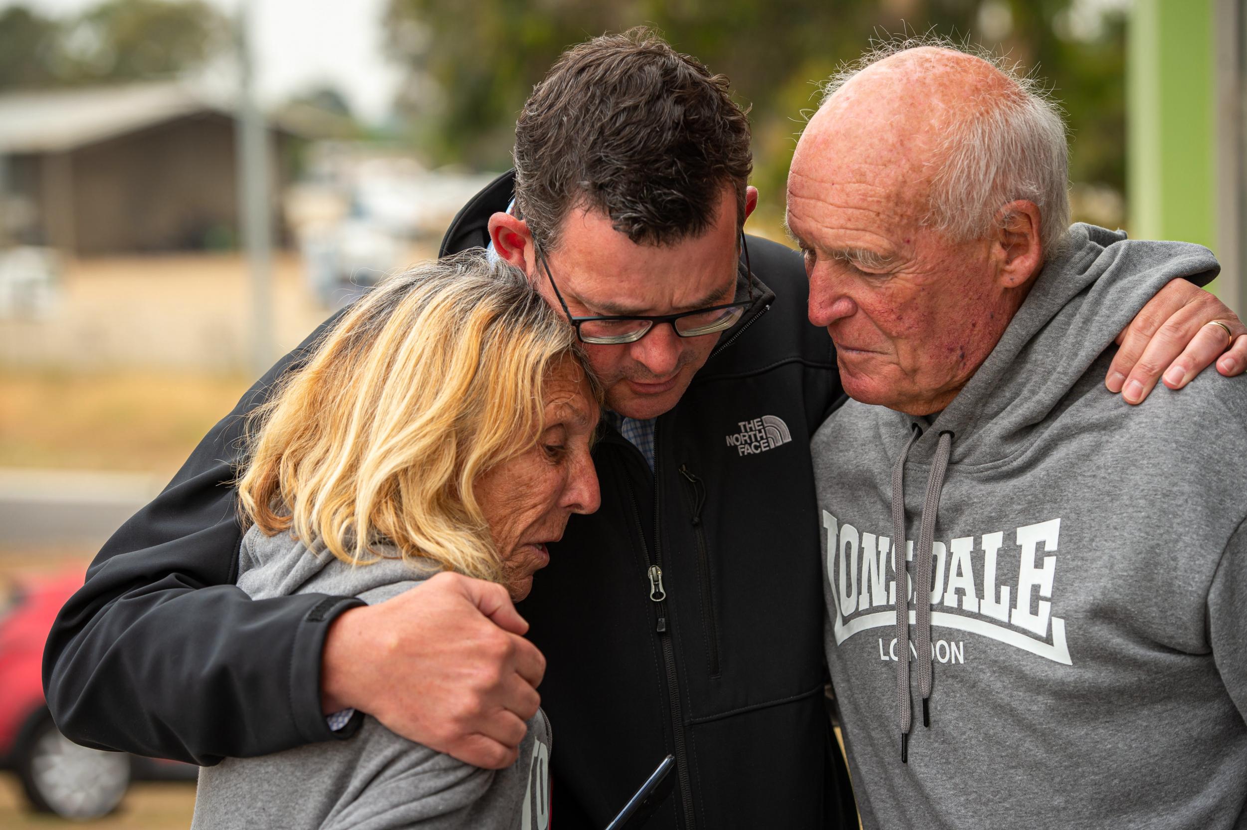 Daniel Andrews, the Victoria premier, comforts a couple who lost their home