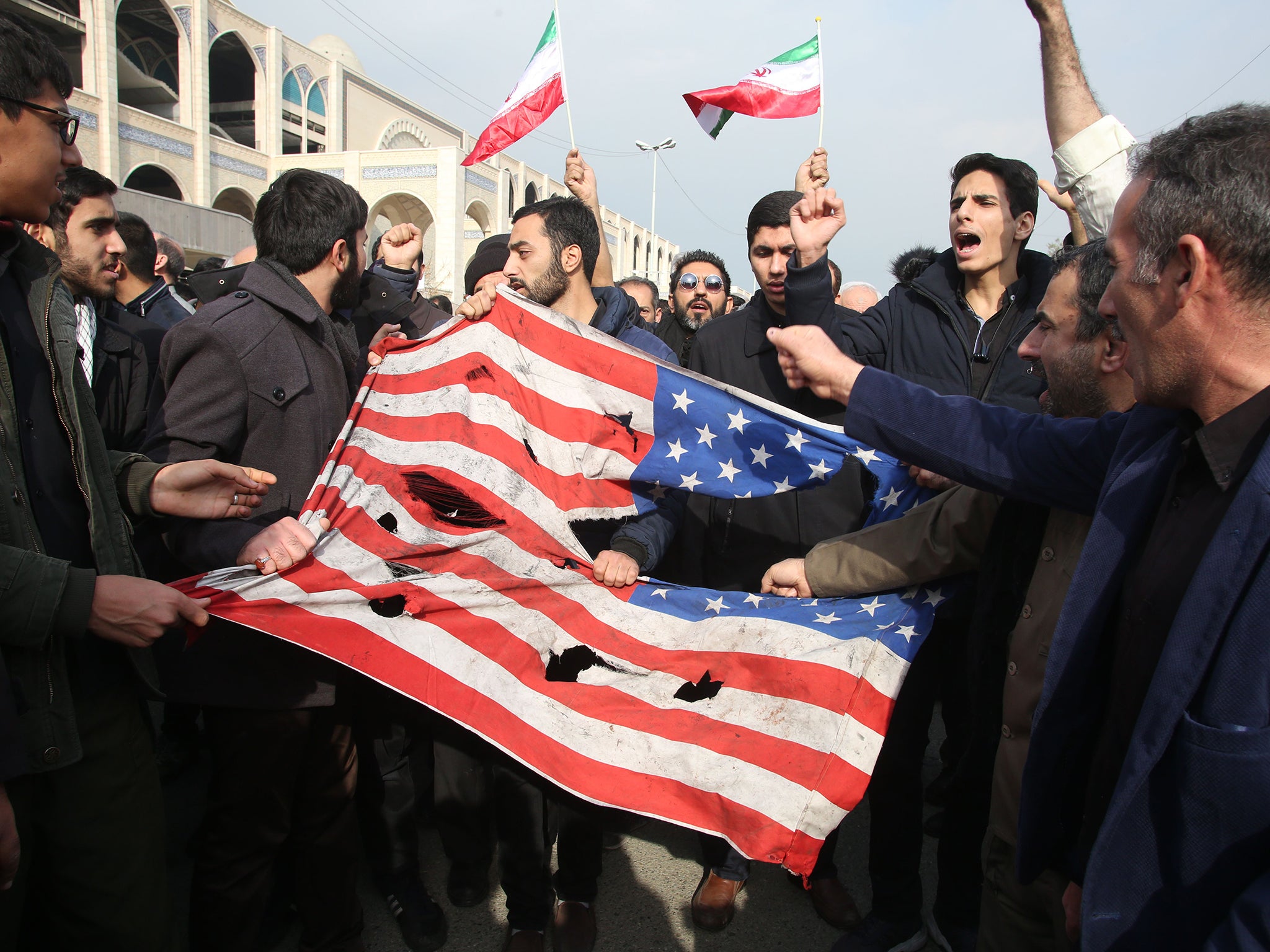 Iranians tear up a US flag during a demonstration in Tehran