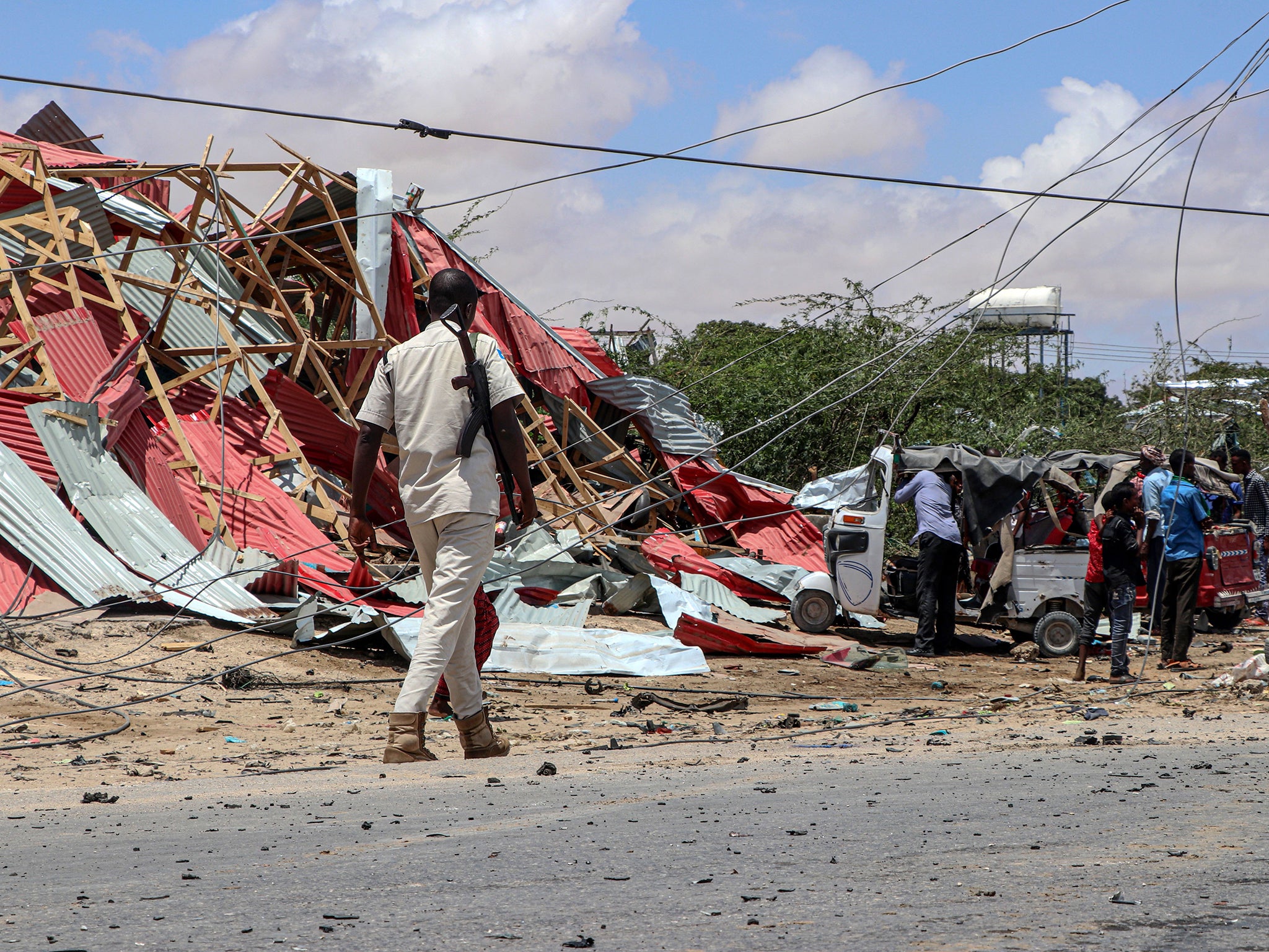 Somali bystanders view wreckage following a suicide car bombing in Mogadishu last year