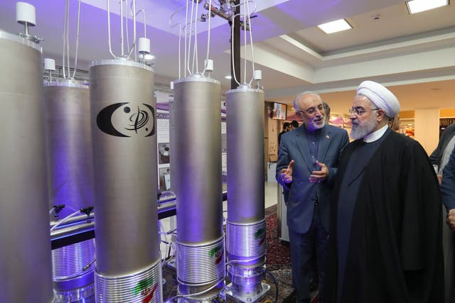 Iranian President Hassan Rouhani (R) and the head of Iran nuclear technology organization Ali Akbar Salehi inspect nuclear technology in Tehran in April 2019