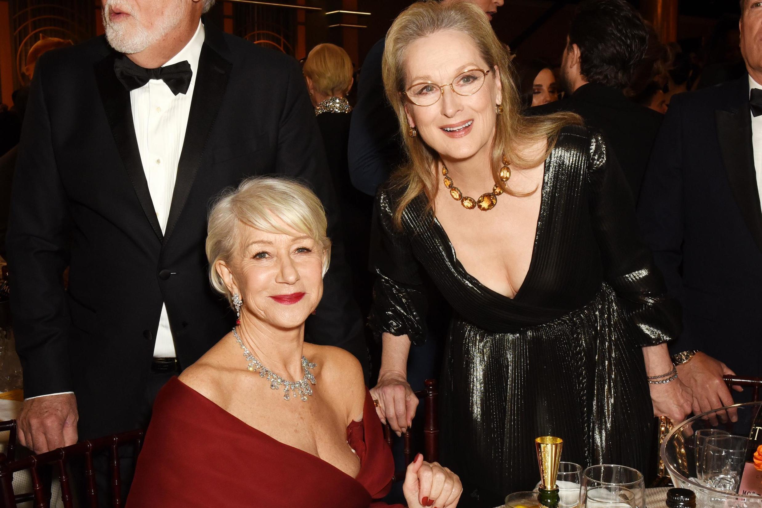Meryl Streep helps Helen Mirren with dress during Golden Globes (Getty)