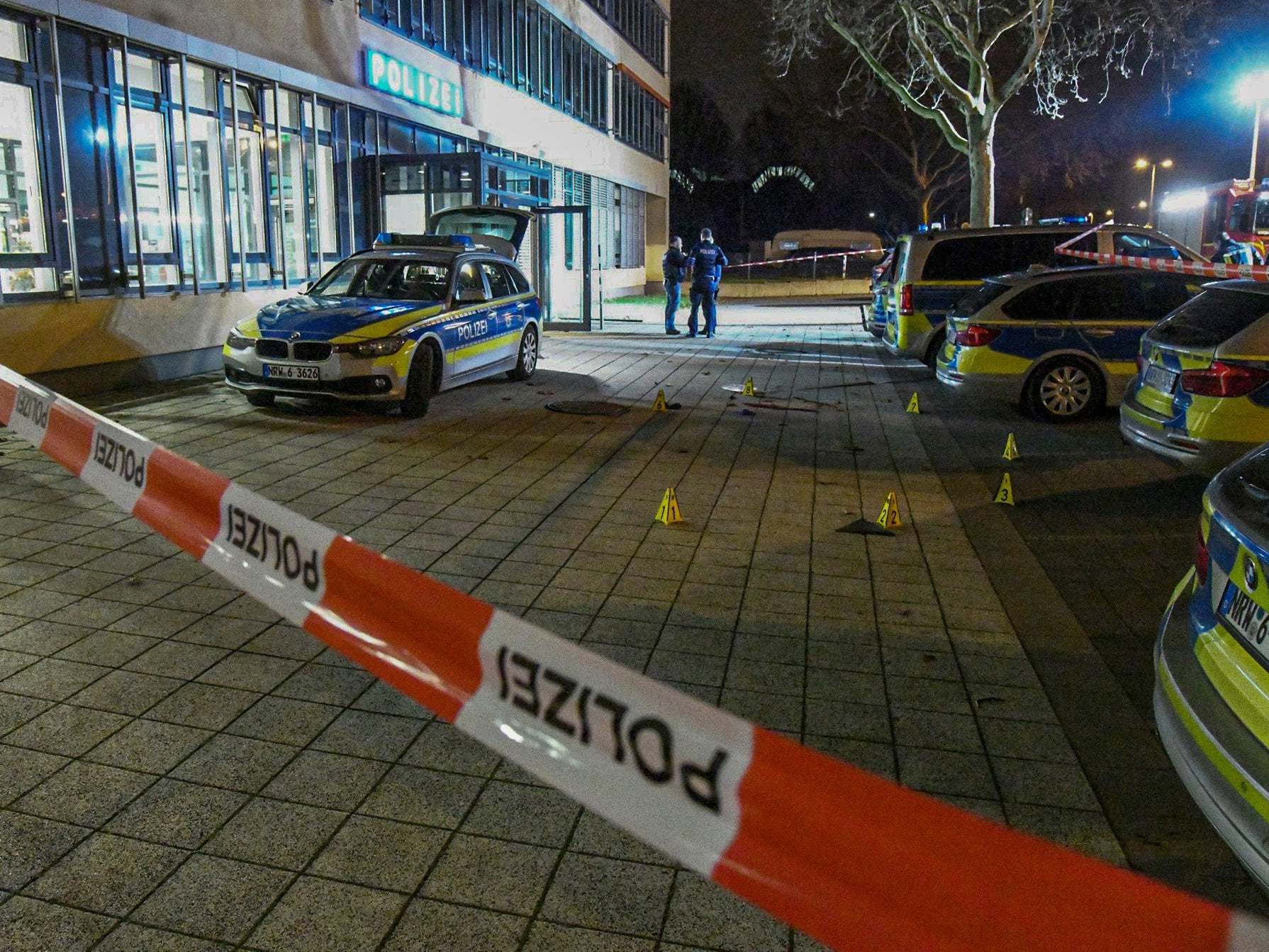 German police officers stand at the crime scene in front of a police station in Gelsenkirchen, Germany