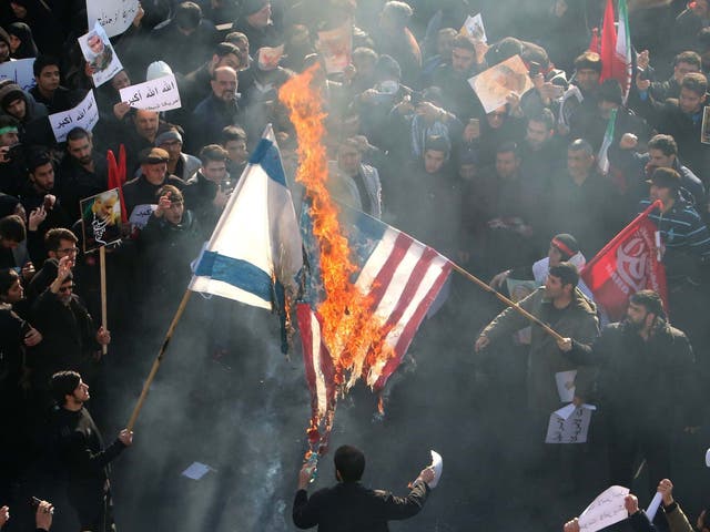 Iranians set a US and an Israeli flag on fire during a funeral procession organised to mourn the slain military commander Qasem Soleimani